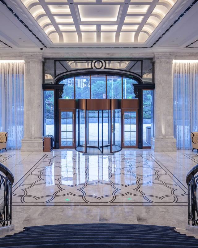 Symmetrical hotel lobby with a double staircase and marble floor